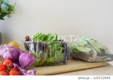Fresh vegetables and vibrant greens arranged on a wooden kitchen counter for healthy eating Fresh vegetables and vibrant greens arranged on a wooden kitchen counter for healthy eating 120712649