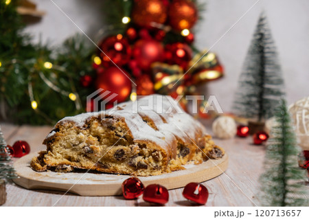 Traditional German Christmas stollen cake in background of handmade festive decor. Winter holiday treats. Vegan baking recipe 120713657