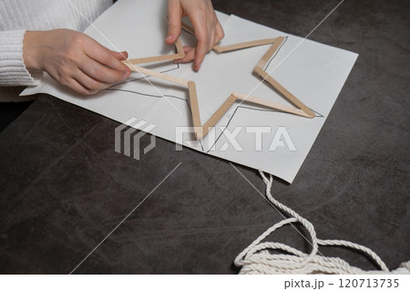 Christmas star made of ice cream sticks. Gift idea. Do it yourself instruction eco-friendly decoration. Zero waste Making handmade presents children's diy projects. Holiday family time Christmas star made of ice cream sticks. Gift idea. Do it yourself instruction eco-friendly decoration. Zero waste Making handmade presents children's diy projects. Holiday family time 120713735