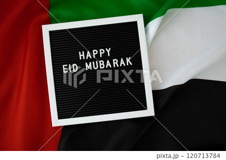 Message text HAPPY EID MUBARAK - happy holidays waving UAE flag on background concept. Greeting card advertisement. Commemoration Day Muslim Ramadan Blessed holy month public holiday 120713784