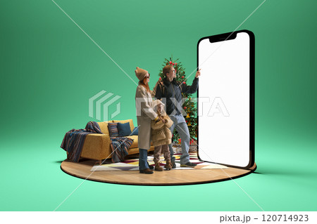 Choosing travel destination. Young family, mother, father and child standing next to giant 3D model of phone with blank screen. Booking tickets 120714923