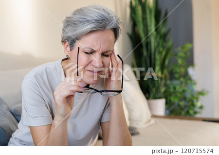 Concept health. An elderly beautiful gray-haired middle-aged woman holds her head with her hands. Concept health. An elderly beautiful gray-haired middle-aged woman holds her head with her hands. 120715574
