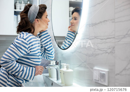 Beautiful smiling young woman posing in front of bathroom mirror enjoy reflection closeup Beautiful smiling young woman posing in front of bathroom mirror enjoy reflection closeup 120715676