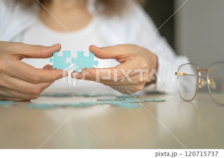 Business woman hands assembling puzzle details concept of finding solution solving problem top view Business woman hands assembling puzzle details concept of finding solution solving problem top view 120715737