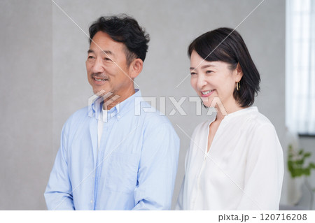 家のリビングで過ごす笑顔のミドル夫婦 家のリビングで過ごす笑顔のミドル夫婦 120716208