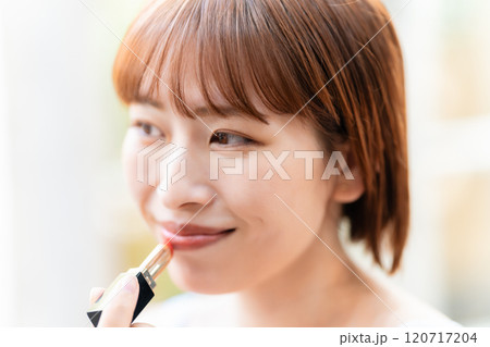口紅を塗るショートボブの若い女性 120717204