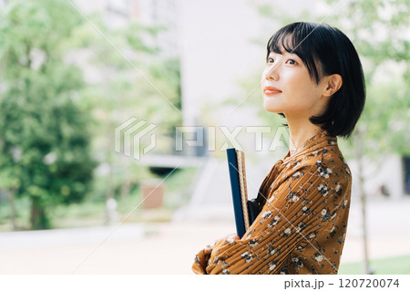 キャンパスを背景にした笑顔の大学生 キャンパスを背景にした笑顔の大学生 120720074