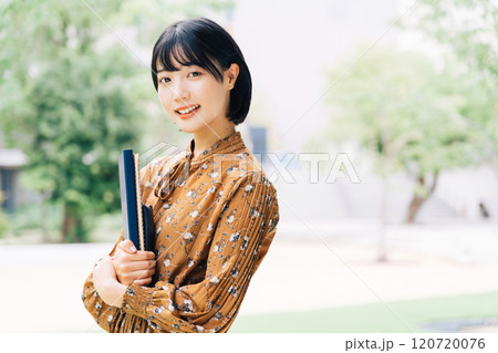 キャンパスを背景にした笑顔の大学生　 120720076