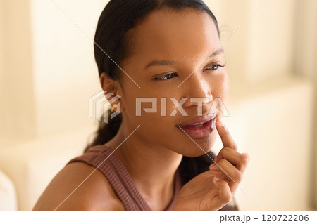 Lip Care Routine: Woman Applying Moisturizer with Thoughtful Expression 120722206