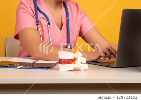 Anatomical lumbar disc herniation model on work desk of doctor in medical clinic. Intervertebral hernia treatment 120723152