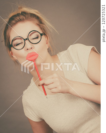 Happy woman holding fake lips on stick 120725321