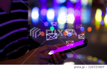 Email notification alert concept. Woman uses a smartphone with glowing email icons above screen, representing digital communication and email notifications against vibrant, online correspondence. 120725907