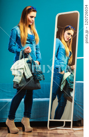 Fashion woman wearing blue denim in front of mirror Fashion woman wearing blue denim in front of mirror 120726034