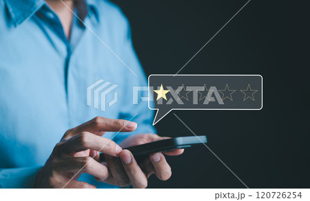 Negative customer review concept. A person use smartphone to give a one-star rating, symbolizing customer dissatisfaction, negative feedback, and online reviews in business reputation. 1 star score, 120726254