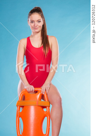 Lifeguard with rescue buoy supervising. 120726312