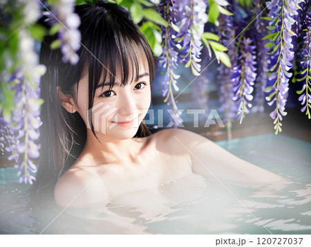 藤の花が咲く温泉露天風呂に入浴中の若い女性 120727037