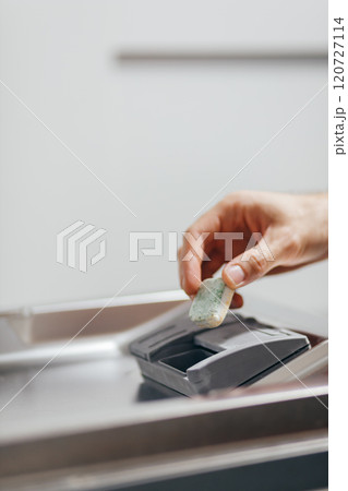 Man putting detergent tablet into open dishwasher indoors, closeup 120727114