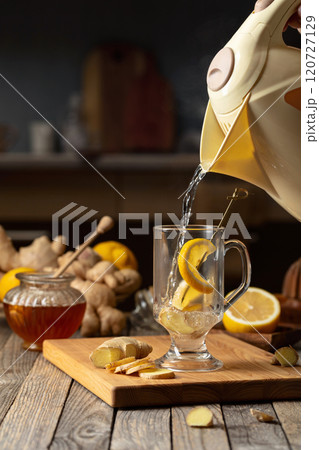 Hot water is poured into a glass for preparing ginger tea. Hot water is poured into a glass for preparing ginger tea. 120727129
