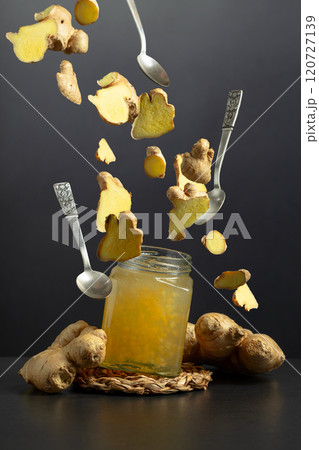 Jar of ginger jam and fresh ginger on a black background. Jar of ginger jam and fresh ginger on a black background. 120727139