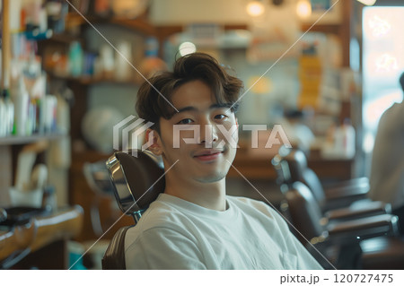 Asian man sitting in a barber chair in a beauty salon. 120727475