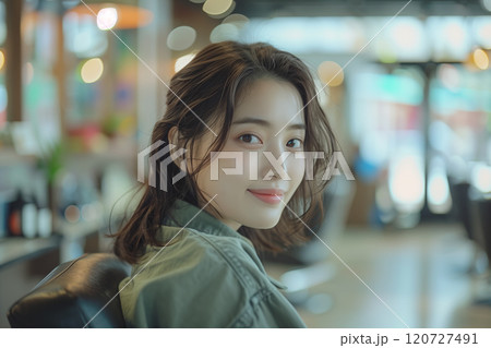Asian woman sitting in a barber chair in a beauty salon. 120727491
