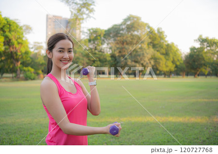 Woman exercising outdoors with dumbbells. Woman exercising outdoors with dumbbells. 120727768