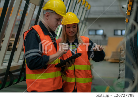 Workers collaborating in a factory setting. 120727799