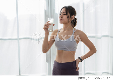 Asian beautiful attractive female sportswear holding glass drinking milk food nutrition healthy with active exercise. contains good fats, which give energy to body. Milk high calcium. Asian beautiful attractive female sportswear holding glass drinking milk food nutrition healthy with active exercise. contains good fats, which give energy to body. Milk high calcium. 120728237