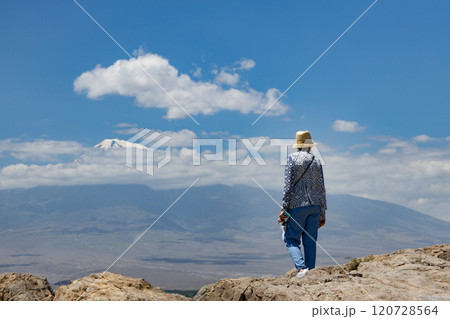 Majestic view of Mount Ararat in Armenia under a clear blue sky with a lone traveler in the foreground Majestic view of Mount Ararat in Armenia under a clear blue sky with a lone traveler in the foreground 120728564