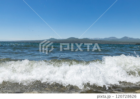 Waves crashing gently at Sevan Lake under a clear blue sky in Armenia on a sunny day 120728626