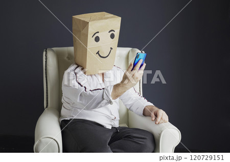 Cheerful man with a bag on his head, with a drawn smiley. 120729151