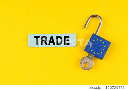 On the yellow surface is an open lock with a key and a sticker with the inscription - TRADE 120729251