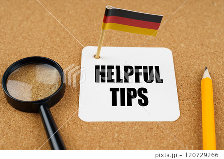 On the table is the flag of Germany, a pencil and a sheet of paper with the inscription - Helpful Tips 120729266