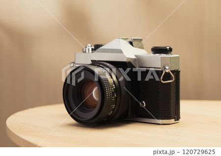 A vintage film camera with a 50mm lens. A vintage film camera with a 50mm lens. 120729625