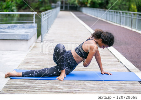 Sporty fit american african women sportswear performing asana yoga, Pose Outdoor active workout. Strong female healthy lifestyle. Relax yoga exercise concept. Sporty fit american african women sportswear performing asana yoga, Pose Outdoor active workout. Strong female healthy lifestyle. Relax yoga exercise concept. 120729668