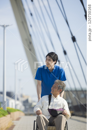 屋外で車椅子を押す介護スタッフ 屋外で車椅子を押す介護スタッフ 120730168