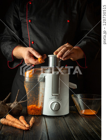 A person prepares fresh carrots and beets, expertly juicing them in a rustic kitchen. The warm lighting enhances the rich colors of the vegetables and the juicer, creating an inviting atmosphere A person prepares fresh carrots and beets, expertly juicing them in a rustic kitchen. The warm lighting enhances the rich colors of the vegetables and the juicer, creating an inviting atmosphere 120730515