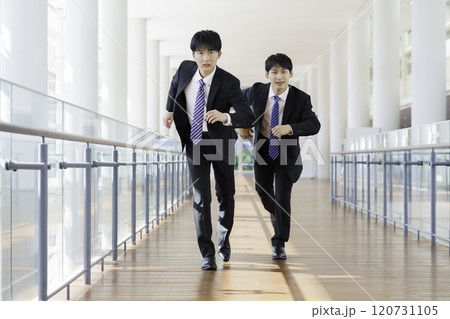 ビルの廊下を走る若いビジネスマン2人 120731105