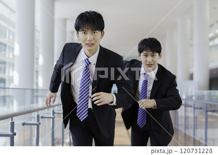 ビルの廊下を走る若いビジネスマン2人 120731228