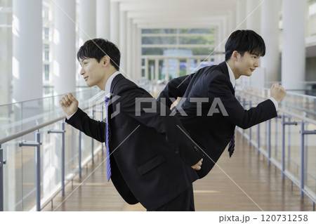 ビルの通路で走るポーズを取るビジネスマン2人 120731258