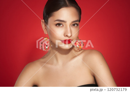 Portrait of beautiful young woman on red background 120732179