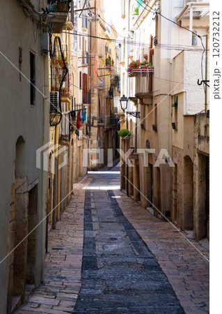 TARRAGONA, SPAIN - AUG 28th, 2017: Deserted street of old European town on a clear Sunny day. The bright walls of the old town of Tarragona in Catalonia TARRAGONA, SPAIN - AUG 28th, 2017: Deserted street of old European town on a clear Sunny day. The bright walls of the old town of Tarragona in Catalonia 120732212