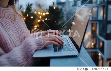 Woman using laptop on a balcony during winter 120735473