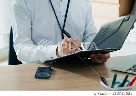 書類にサインするビジネスマン 120735525