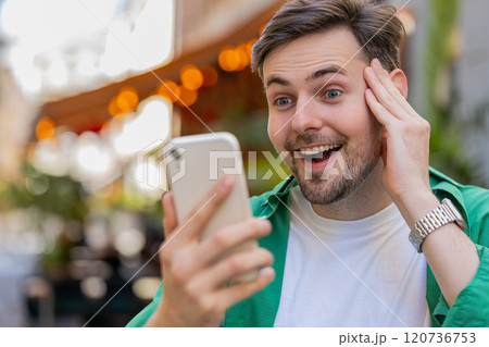 Excited happy winner man using smartphone looking amazed at screen celebrating win good message news 120736753