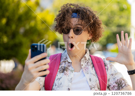 Tourist man using mobile smartphone celebrating win receive good message news wow emotion outdoors Tourist man using mobile smartphone celebrating win receive good message news wow emotion outdoors 120736786