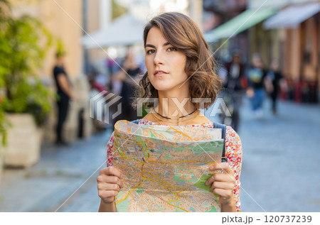 Woman lost while traveling in Europe city, exploring sightseeing, navigating holds tourist paper map Woman lost while traveling in Europe city, exploring sightseeing, navigating holds tourist paper map 120737239