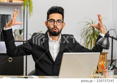 Excited amazed Indian businessman looking shocked surprised wow showing head explosion gesture Excited amazed Indian businessman looking shocked surprised wow showing head explosion gesture 120737245