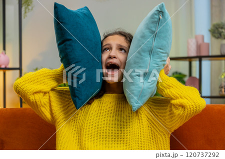 Neighbors repair work irritated girl by loud music at home cover ears with pillows annoyed by noise Neighbors repair work irritated girl by loud music at home cover ears with pillows annoyed by noise 120737292