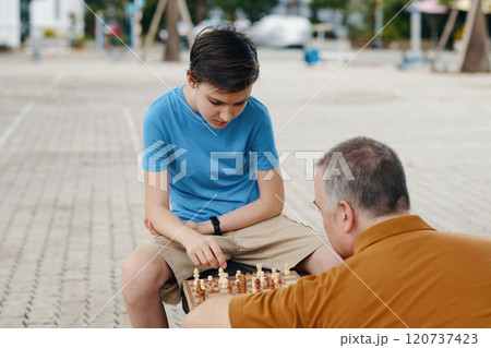 Boy Learning To Play Chess With Grandfather Boy Learning To Play Chess With Grandfather 120737423